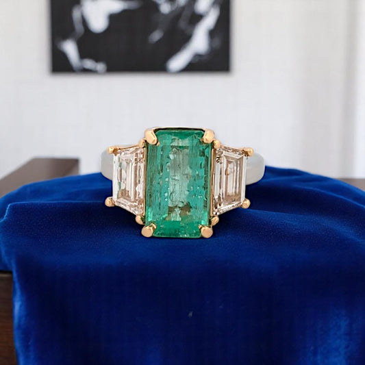 Platinum and 18k yellow gold ring featuring a 4.94 ct emerald-cut emerald and 6.98 ctw lab diamonds, size 6.25.