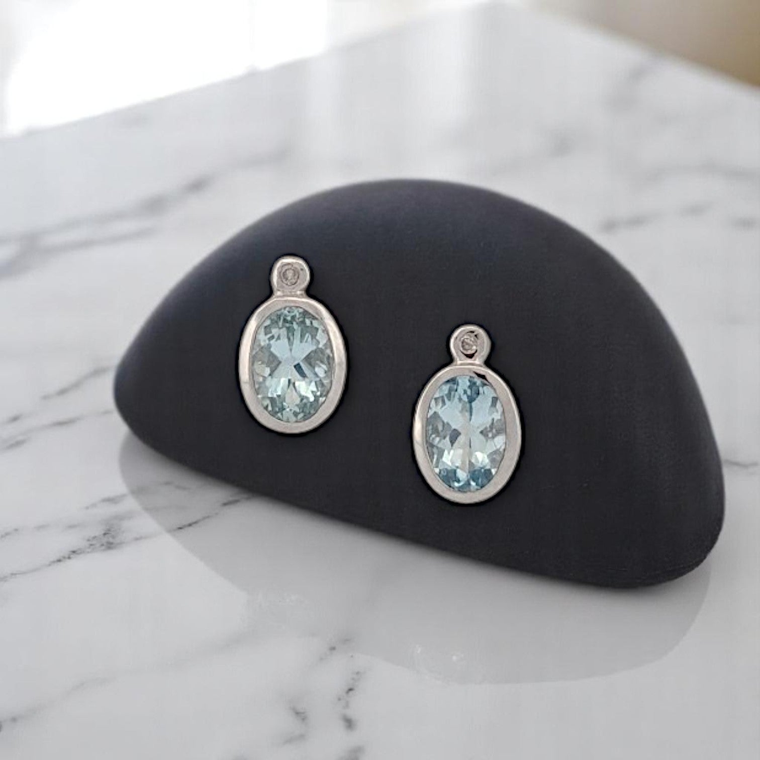 14k white gold post earrings with bezel set oval aquamarines and natural diamonds